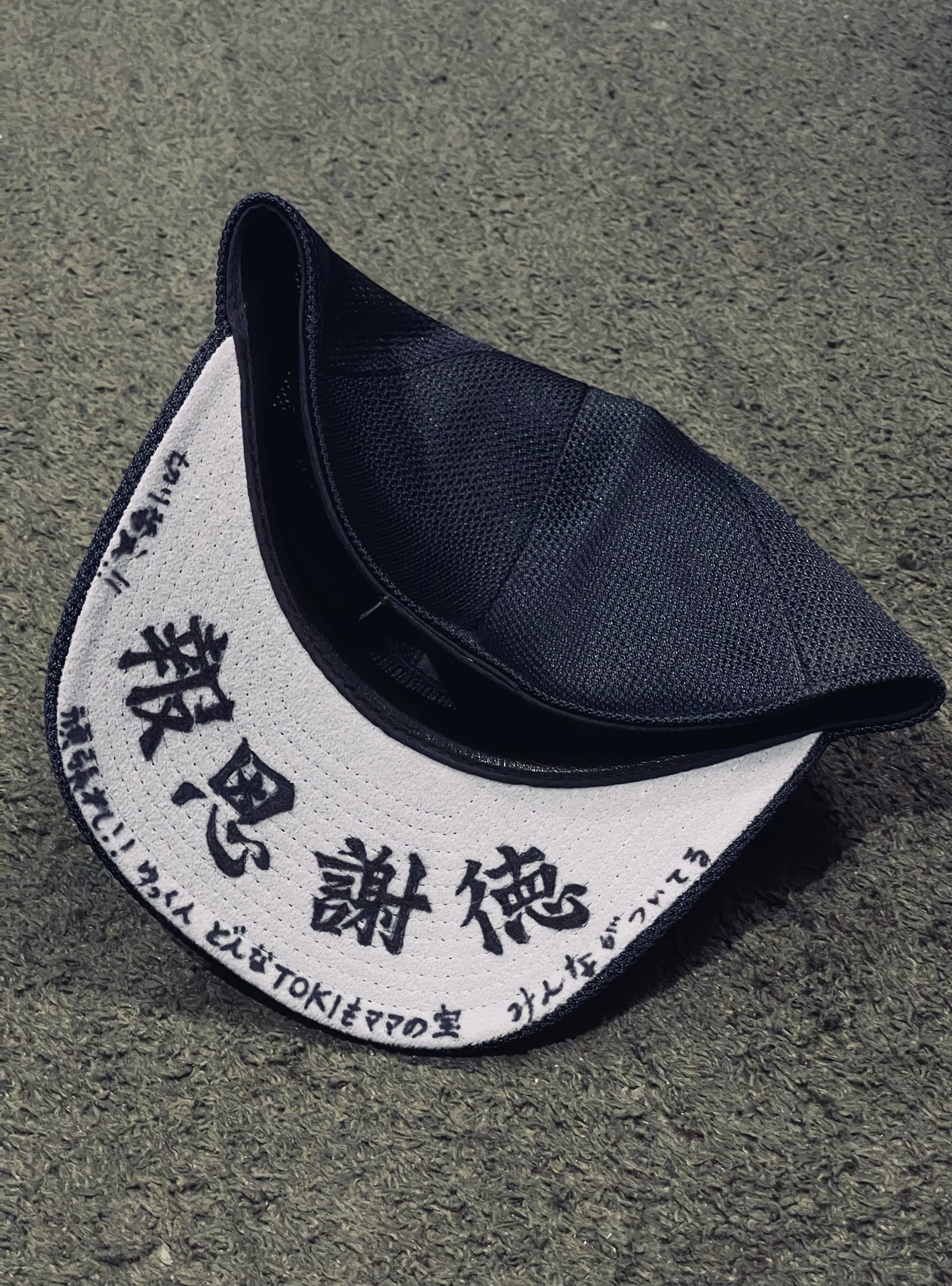 帽子のつばに書かれた「報恩謝徳」の文字