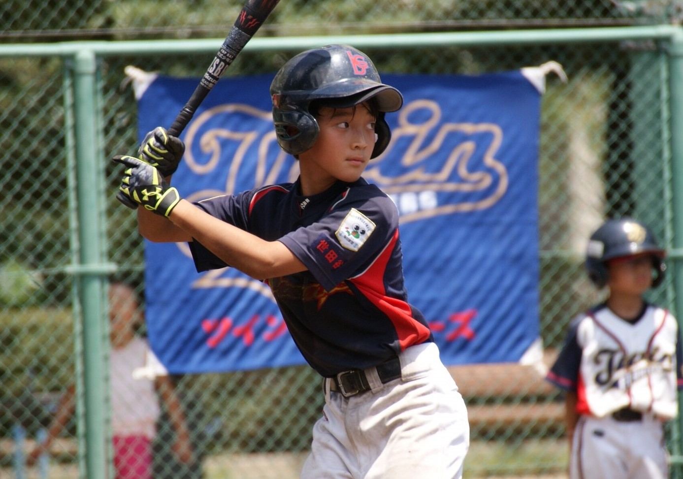 幼稚舎時代の直睦さんがバットを構えている写真